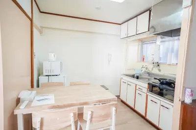 a kitchen with a wooden table and a sink at 302Room 1 Stop from Ikebukuro Entire 33m on 3st Floor 2 Bedrooms for up to 6 Guests 3Minute Walk to Don Quijote in Tokyo