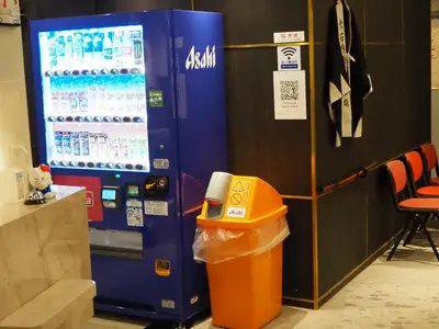 a drink machine with a trash can next to it at Phoenix Inn in Tokyo