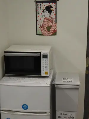 a microwave oven sitting on top of a refrigerator at Phoenix Inn in Tokyo