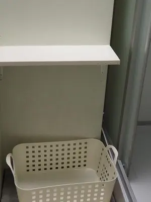 a white shelf with a basket under a shelf at Phoenix Inn in Tokyo