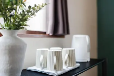 a black table with a vase and three white candles at TokyoDisneyAkihabara,Entire House,8Ppl,5Bedl60m2 in Tokyo