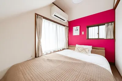 a bedroom with a large bed and a pink wall at TokyoDisneyAkihabara,Entire House,8Ppl,5Bedl60m2 in Tokyo
