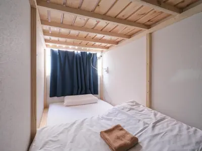 a small bedroom with a bed with a blue curtain at Akabane Dormitory \u8d64\u7fbd\u30c9\u30df\u30c8\u30ea\u30fc - Share Room For Male Only \u7537\u6027\u5c02\u7528\u30c9\u30df\u30c8\u30ea\u30fc in Tokyo