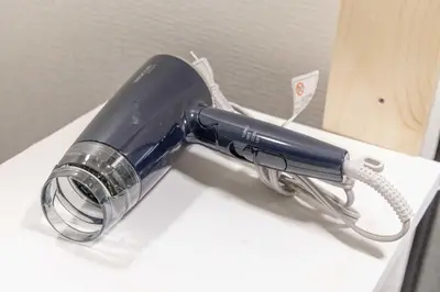 a blue hairdryer is on a table at Akabane Dormitory \u8d64\u7fbd\u30c9\u30df\u30c8\u30ea\u30fc - Share Room For Male Only \u7537\u6027\u5c02\u7528\u30c9\u30df\u30c8\u30ea\u30fc in Tokyo