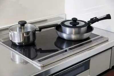 a pair of pots and pans sitting on top of a stove at New - 4 min to Shinjuku! 4 Bedrooms Villa 970 sq ft in Koenji, 10 people, 8 min walk to JR Koenji station - GRADIA Koenji Hotel in Tokyo