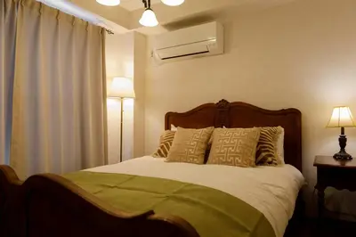a bedroom with a bed and two lamps and a window at New - 4 min to Shinjuku! 4 Bedrooms Villa 970 sq ft in Koenji, 10 people, 8 min walk to JR Koenji station - GRADIA Koenji Hotel in Tokyo