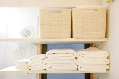 a shelf with towels and baskets in a bathroom at New - 4 min to Shinjuku! 4 Bedrooms Villa 970 sq ft in Koenji, 10 people, 8 min walk to JR Koenji station - GRADIA Koenji Hotel in Tokyo