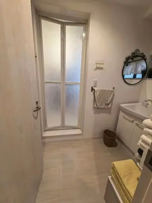 a bathroom with a door and a sink and a mirror at AYA House in Tokyo