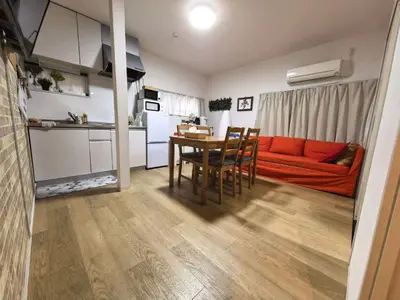 a living room with a red couch and a table at AYA House in Tokyo
