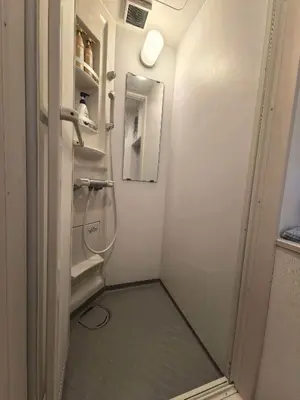 a small bathroom with a shower and a mirror at AYA House in Tokyo