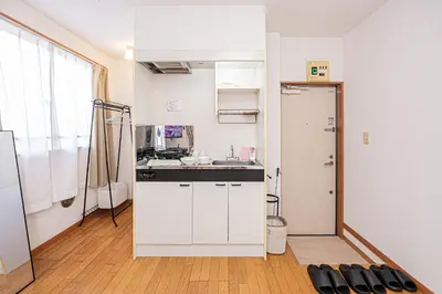 a kitchen with white cabinets and a sink and a door at Mi-APT Honkomagome in Tokyo