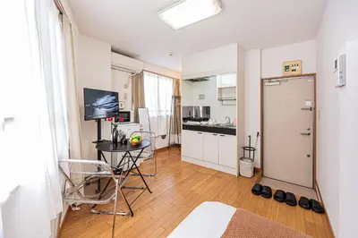 a living room with a table and a kitchen at Mi-APT Honkomagome in Tokyo