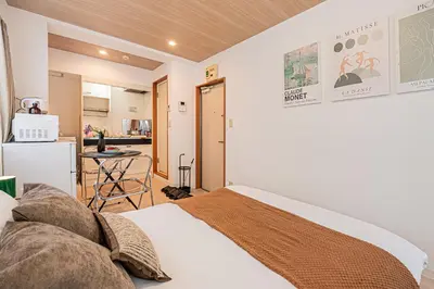 a bedroom with a bed and a small kitchen at Mi-APT Honkomagome in Tokyo
