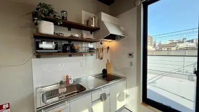 a kitchen with a sink and a large window at SW House in Tokyo
