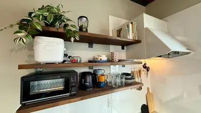 a kitchen with a microwave on a shelf at SW House in Tokyo