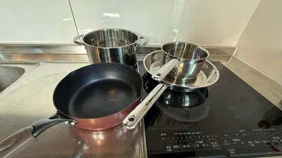 two measuring cups and a pan on top of a stove at SW House in Tokyo