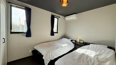 a bedroom with two beds and a window at SW House in Tokyo