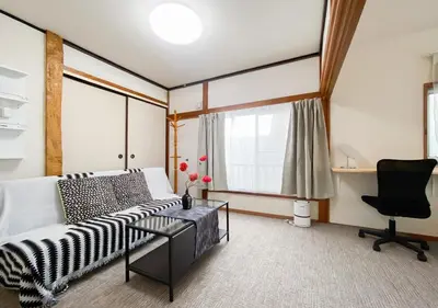 a living room with a bed and a desk and a chair at gjbbkoiwa in Tokyo