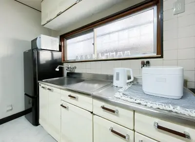 a kitchen with a sink and a black refrigerator at gjbbkoiwa in Tokyo
