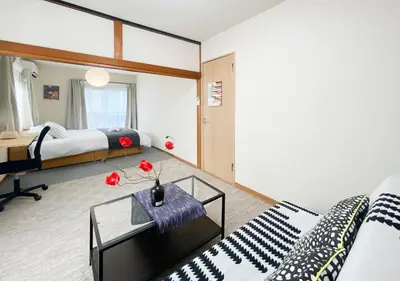 a bedroom with a bed and a table with flowers on it at gjbbkoiwa in Tokyo
