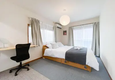 a bedroom with a bed and a desk and a chair at gjbbkoiwa in Tokyo