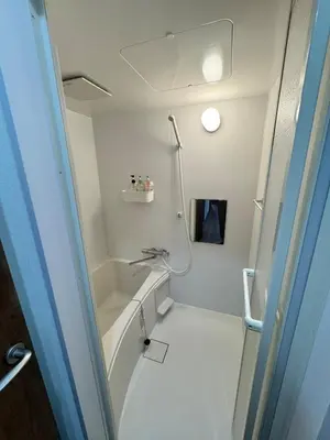 a small bathroom with a shower and a sink at Akihabara, Skytree, Disney, Asakusa Temple, Traditional Japanese Ryokan, Airport Pick-up and Drop-off in Tokyo
