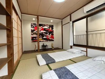 two beds in a room with a large window at Akihabara, Skytree, Disney, Asakusa Temple, Traditional Japanese Ryokan, Airport Pick-up and Drop-off in Tokyo