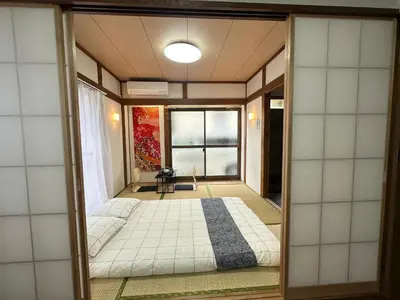 a bedroom with a large bed in a room at Akihabara, Skytree, Disney, Asakusa Temple, Traditional Japanese Ryokan, Airport Pick-up and Drop-off in Tokyo