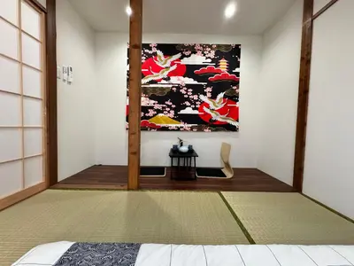 a room with a bed and a painting on the wall at Akihabara, Skytree, Disney, Asakusa Temple, Traditional Japanese Ryokan, Airport Pick-up and Drop-off in Tokyo