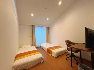 two beds in a room with a desk and a television at \u738b\u5b50Stay\u4f73 in Tokyo