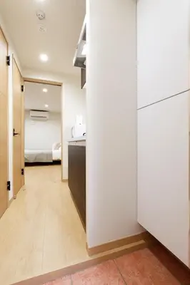 a kitchen with white cabinets and a bedroom at LIFE TOWN Kameari in Tokyo