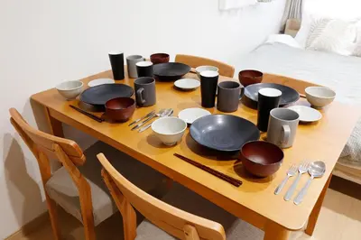 a wooden table with plates and utensils on it at LIFE TOWN Kameari in Tokyo