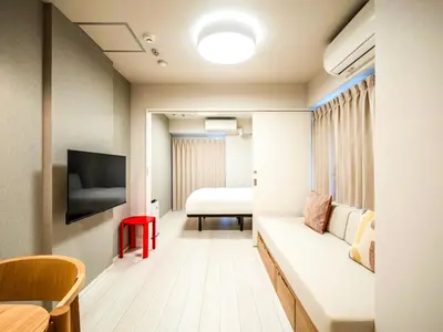 a hotel room with a couch and a bed at Section L Akihabara in Tokyo