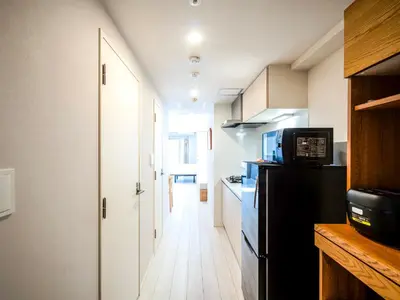 a kitchen with a black refrigerator and a microwave at Section L Akihabara in Tokyo