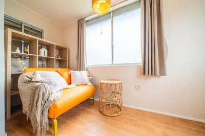 an orange couch in a room with a window at #34-Zen Home- \u6771\u745e\u6c5f in Tokyo