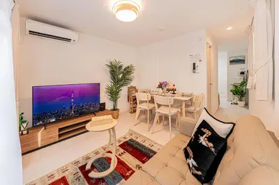 a living room with a couch and a large tv at \u6625\u65e5\u5c45 Kasuga House in Tokyo