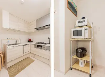a kitchen with white cabinets and white appliances at \u6625\u65e5\u5c45 Kasuga House in Tokyo