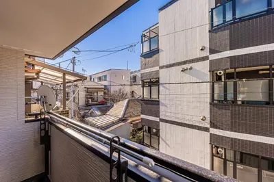 a balcony with a view of a building at \u6625\u65e5\u5c45 Kasuga House in Tokyo