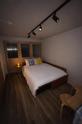 a bedroom with a large white bed and a chair at #6 WiFi無料&新宿5分! 清潔 安全 お洒落な部屋! in Tokyo