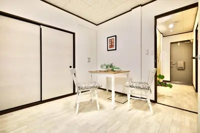 a dining room with a table and two chairs at \u30a8\u30de\u30fc\u30ec\u6771\u5c0f\u5ca9103 \u5c0f\u5ca9\u99c5\u5f92\u6b695\u5206 \u6700\u59275\u540d \u548c\u5ba4\u7573 in Tokyo