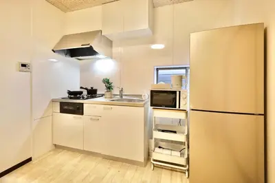 a small kitchen with a refrigerator and a sink at \u30a8\u30de\u30fc\u30ec\u6771\u5c0f\u5ca9103 \u5c0f\u5ca9\u99c5\u5f92\u6b695\u5206 \u6700\u59275\u540d \u548c\u5ba4\u7573 in Tokyo