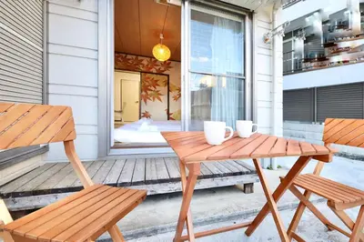 a wooden table and two chairs on a porch at \u30a8\u30de\u30fc\u30ec\u6771\u5c0f\u5ca9103 \u5c0f\u5ca9\u99c5\u5f92\u6b695\u5206 \u6700\u59275\u540d \u548c\u5ba4\u7573 in Tokyo