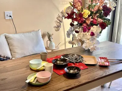 a table with plates and a vase of flowers at \u4f4d\u4e8e\u4e1c\u4eac\u6c5f\u6237\u5ddd\u533a\u4e1c\u5c0f\u5ca9\u662f\u9002\u5408\u5bb6\u5ead\u4e0e\u670b\u53cb\u56e2\u4f53\u5165\u4f4f\u7684\u6574\u5957\u65e5\u5f0f\u6c11\u5bbf in Tokyo