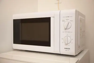 a white microwave oven sitting on top of a counter at Imb\u753a\u5c4b4\u4e01\u76ee102 in Tokyo