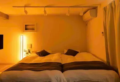 a bedroom with a large bed with yellow walls at Jeminith Ikebukuro Tokyo in Tokyo