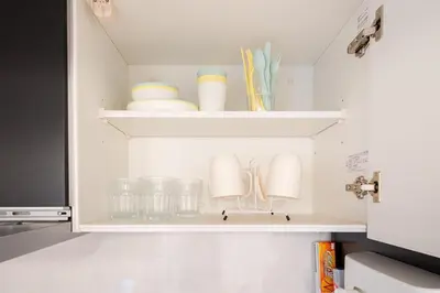 a cupboard with plates and dishes on it at Jeminith Ikebukuro Tokyo in Tokyo