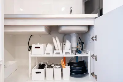 a kitchen with a sink and a shelf with utensils at Jeminith Ikebukuro Tokyo in Tokyo