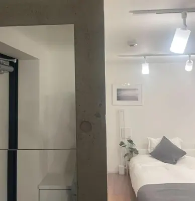 a bedroom with a bed and a glass wall at Jeminith Ikebukuro Tokyo in Tokyo