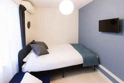a bedroom with a bed and a tv on the wall at Grado Horikiri in Tokyo