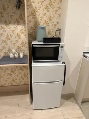 a microwave oven sitting on top ofrigerators in a kitchen at The Asakusa Townhouse in Tokyo